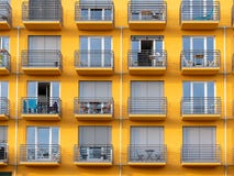 Imagem da construção alta amarela da elevação com janelas e balcões e cortinas fotos de stock Imagem da construção alta amarela da elevação com janelas e balcões e cortinas fotos de stock