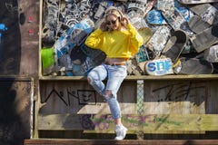 Imagem de uma jovem mulher que escuta e que tem o divertimento ao escutar a música através dos fones de ouvido, em um fundo dos s foto de stock Imagem de uma jovem mulher que escuta e que tem o divertimento ao escutar a música através dos fones de ouvido, em um fundo dos s foto de stock