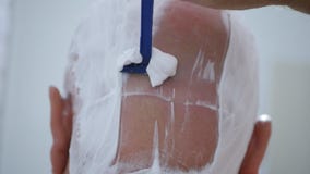 Imagem próxima com o homem que barbeia sua cabeça imagem de stock Imagem próxima com o homem que barbeia sua cabeça imagem de stock