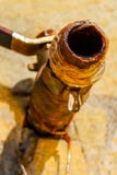 Imagen ascendente cercana de un descenso del goteo del agua de un golpecito oxidado imágenes de archivo libres de regalías Imagen ascendente cercana de un descenso del goteo del agua de un golpecito oxidado imágenes de archivo libres de regalías
