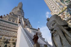 Imagen ascendente cercana de una estatua china del guarda con Wat Arun en el fondo foto de archivo libre de regalías Imagen ascendente cercana de una estatua china del guarda con Wat Arun en el fondo foto de archivo libre de regalías