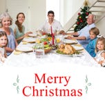 Imagen compuesta de la familia que tiene comida de la Navidad junto imagen de archivo libre de regalías Imagen compuesta de la familia que tiene comida de la Navidad junto imagen de archivo libre de regalías