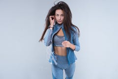 Imagen cosechada de una mujer sana joven de la aptitud en ropa de deportes que escucha la música con los auriculares fotografía de archivo libre de regalías Imagen cosechada de una mujer sana joven de la aptitud en ropa de deportes que escucha la música con los auriculares fotografía de archivo libre de regalías