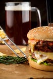 Imbarchi con il doppio hamburger saporito sulla tavola di legno immagine stock libera da diritti Imbarchi con il doppio hamburger saporito sulla tavola di legno immagine stock libera da diritti