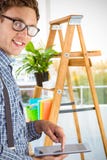 Immagine composita dell'uomo d'affari geeky facendo uso del suo pc della compressa fotografie stock Immagine composita dell'uomo d'affari geeky facendo uso del suo pc della compressa fotografie stock