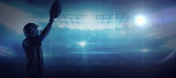 Immagine composita della condizione del giocatore di football americano con il casco e la palla di rugby immagini stock libere da diritti Immagine composita della condizione del giocatore di football americano con il casco e la palla di rugby immagini stock libere da diritti