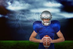 Immagine composita della palla sicura della tenuta del giocatore di football americano immagine stock Immagine composita della palla sicura della tenuta del giocatore di football americano immagine stock