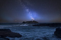 Immagine composita della Via Lattea vibrante sopra paesaggio di Godrevy Ligh fotografia stock libera da diritti Immagine composita della Via Lattea vibrante sopra paesaggio di Godrevy Ligh fotografia stock libera da diritti