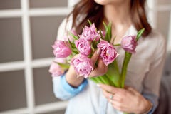 Immagine del primo piano di una donna in camicia bianca che mostra un mazzo dei fiori della molla Congratulazioni sulla festa fotografia stock Immagine del primo piano di una donna in camicia bianca che mostra un mazzo dei fiori della molla Congratulazioni sulla festa fotografia stock