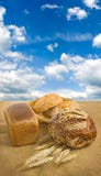 Immagine di pane e di grano contro il primo piano del cielo fotografia stock Immagine di pane e di grano contro il primo piano del cielo fotografia stock