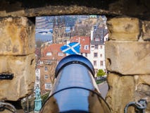 Immagine di vecchio canone nero che tende dal castello sulla bandiera scozzese fotografia stock libera da diritti Immagine di vecchio canone nero che tende dal castello sulla bandiera scozzese fotografia stock libera da diritti