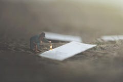 Immagine surreale di una donna che legge le pagine gigantesche di un libro sparso fra la natura immagini stock Immagine surreale di una donna che legge le pagine gigantesche di un libro sparso fra la natura immagini stock