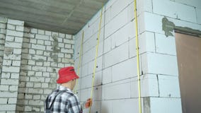 Inclinaison tirée du constructeur installant des rails en métal sur des brides sur le mur de bloc clips vidéos Inclinaison tirée du constructeur installant des rails en métal sur des brides sur le mur de bloc clips vidéos
