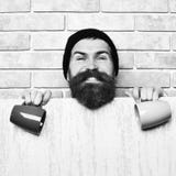 Inconformista cauc?sico brutal barbudo con la hoja y las tazas de papel imagenes de archivo Inconformista cauc?sico brutal barbudo con la hoja y las tazas de papel imagenes de archivo