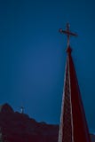 Incrocio della guglia della chiesa sopra le montagne fotografie stock Incrocio della guglia della chiesa sopra le montagne fotografie stock