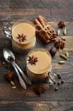 Indier Masala Chai Tea Kryddat te med mjölkar i koppar för en tappning på den lantliga trätabellen fotografering för bildbyråer Indier Masala Chai Tea Kryddat te med mjölkar i koppar för en tappning på den lantliga trätabellen fotografering för bildbyråer