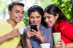 Indisch meisje die beelden op telefoon tonen aan vrienden stock afbeelding Indisch meisje die beelden op telefoon tonen aan vrienden stock afbeelding