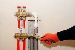 Individuo de la instalación de la calefacción de casa Un fontanero ata el tubo a la calefacción del colector Instalación de la ca Imágenes de archivo libres de regalías Individuo de la instalación de la calefacción de casa Un fontanero ata el tubo a la calefacción del colector Instalación de la ca Imágenes de archivo libres de regalías