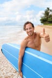 Individuo de la persona que practica surf feliz con la resaca que practica surf haciendo los pulgares para arriba foto de archivo libre de regalías Individuo de la persona que practica surf feliz con la resaca que practica surf haciendo los pulgares para arriba foto de archivo libre de regalías