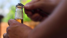 Individuo que abre una cerveza de la botella almacen de metraje de vídeo Individuo que abre una cerveza de la botella almacen de metraje de vídeo