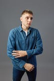 Individuo vestido en una situación blanca de la camiseta, de los vaqueros y de la camisa de los vaqueros con sus brazos doblados foto de archivo Individuo vestido en una situación blanca de la camiseta, de los vaqueros y de la camisa de los vaqueros con sus brazos doblados foto de archivo