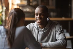 Indivíduo alegre preto que conversa com a menina durante datar da velocidade fotografia de stock Indivíduo alegre preto que conversa com a menina durante datar da velocidade fotografia de stock