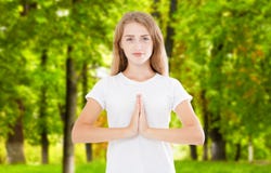 Indoor closeup of beautiful European woman in white T-shirt isolated on park background practicing yoga and meditation stock images Indoor closeup of beautiful European woman in white T-shirt isolated on park background practicing yoga and meditation stock images