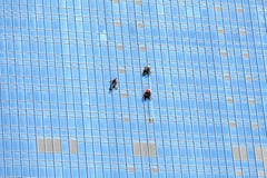 Industrial Climbers Working On Mirror Building Facade Royalty Free Stock Image