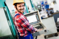 Industry Worker entering data in CNC machine at factory stock image Industry Worker entering data in CNC machine at factory stock image