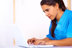 Infermiera che per mezzo di un computer portatile immagini stock libere da diritti Infermiera che per mezzo di un computer portatile immagini stock libere da diritti