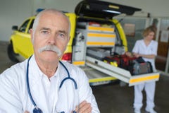 Infirmier de portrait avec l'ambulance à l'arrière-plan photographie stock Infirmier de portrait avec l'ambulance à l'arrière-plan photographie stock