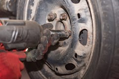 Ingegnere di meccatronica che cambia le gomme di automobile fotografie stock libere da diritti Ingegnere di meccatronica che cambia le gomme di automobile fotografie stock libere da diritti