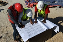 Ingegneri nel cantiere con i modelli immagine stock Ingegneri nel cantiere con i modelli immagine stock