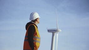 Ingeniero de la energía del molino de viento a trabajar con la tableta en la puesta del sol ambiental almacen de metraje de vídeo Ingeniero de la energía del molino de viento a trabajar con la tableta en la puesta del sol ambiental almacen de metraje de vídeo