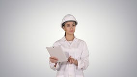 Ingeniero de la mujer que comprueba la información y objetos en su tableta en fondo de la pendiente fotografía de archivo Ingeniero de la mujer que comprueba la información y objetos en su tableta en fondo de la pendiente fotografía de archivo
