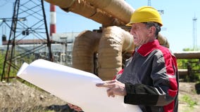 Ingeniero del mantenimiento con el dibujo del proyecto en la estación del electropower del calor almacen de video Ingeniero del mantenimiento con el dibujo del proyecto en la estación del electropower del calor almacen de video