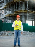 Ingenieur bij bouwwerf het stellen tegen steiger stock foto Ingenieur bij bouwwerf het stellen tegen steiger stock foto