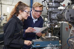 Ingenieur Showing Apprentice How aan Gebruiksboor in Fabriek royalty-vrije stock afbeeldingen Ingenieur Showing Apprentice How aan Gebruiksboor in Fabriek royalty-vrije stock afbeeldingen
