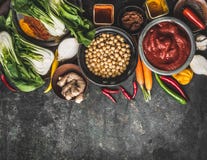 Ingredienti alimentari del vegetariano e del vegano: ceci, erbe, spezie, zenzero e cavolo cinese su fondo rustico, vista superior fotografia stock Ingredienti alimentari del vegetariano e del vegano: ceci, erbe, spezie, zenzero e cavolo cinese su fondo rustico, vista superior fotografia stock