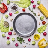 Ingredients for cooking vegetarian food, corn, radishes, rosemary, pepper, oil, seasonings, lined around pan place for text,fr Stock Images Ingredients for cooking vegetarian food, corn, radishes, rosemary, pepper, oil, seasonings, lined around pan place for text,fr Stock Images