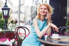 Ingwermädchen im blauen Kleid sprechend am Telefon, Foto getont stockbilder Ingwermädchen im blauen Kleid sprechend am Telefon, Foto getont stockbilder