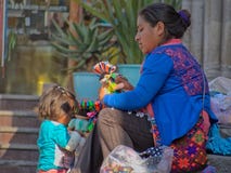 Inheemse Mexicaanse vrouw en kind verkopende poppen in de straten van San Miguel de Allende Royalty-vrije Stock Foto Inheemse Mexicaanse vrouw en kind verkopende poppen in de straten van San Miguel de Allende Royalty-vrije Stock Foto