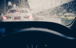 Innenansichtautofenster mit Regentropfen auf Glas oder der Windschutzscheibe, unscharfer Verkehr am regnerischen Tag in der Stadt lizenzfreie stockfotos Innenansichtautofenster mit Regentropfen auf Glas oder der Windschutzscheibe, unscharfer Verkehr am regnerischen Tag in der Stadt lizenzfreie stockfotos