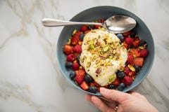 Insalata di bacca con le fragole, i mirtilli, il lampone, il pistacchio, la scorza di limone e la crema del quark dell'olio di li fotografia stock Insalata di bacca con le fragole, i mirtilli, il lampone, il pistacchio, la scorza di limone e la crema del quark dell'olio di li fotografia stock