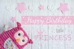 The inscription happy birthday to a little princess. Birthday card girls. Toy owl and stars on wooden background