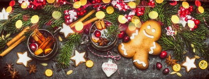 Insegna di Natale con l'uomo di pan di zenzero, i biscotti, il vin brulé, le decorazioni di festa, i rami dell'abete e l'illumina Immagini Stock Insegna di Natale con l'uomo di pan di zenzero, i biscotti, il vin brulé, le decorazioni di festa, i rami dell'abete e l'illumina Immagini Stock
