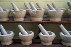 Insiemi del mortaio e del pestello nell'organizzazione di pietra del granito grigio chiaro di colore sullo scaffale di legno da v fotografia stock Insiemi del mortaio e del pestello nell'organizzazione di pietra del granito grigio chiaro di colore sullo scaffale di legno da v fotografia stock