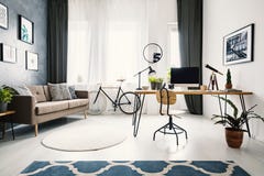Installatie en houten stoel bij bureau in helder flatbinnenland met stock foto Installatie en houten stoel bij bureau in helder flatbinnenland met stock foto