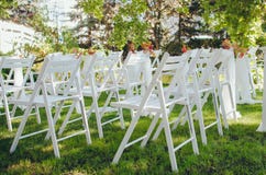 Installation de mariage C?r?monie dans la poitrine de la nature Chaises blanches avec des fleurs r?gl?es dans l'herbe photographie stock libre de droits Installation de mariage C?r?monie dans la poitrine de la nature Chaises blanches avec des fleurs r?gl?es dans l'herbe photographie stock libre de droits