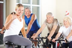 Instructeur de forme physique dans le gymnase tenant des pouces Images libres de droits Instructeur de forme physique dans le gymnase tenant des pouces Images libres de droits